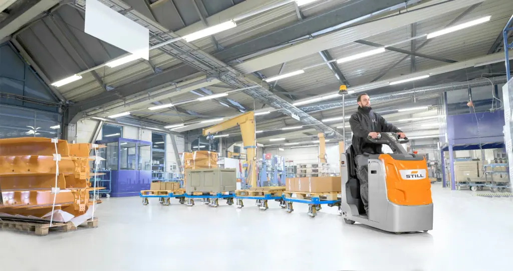 STILL LTX 20 üretim holünde tekerlekli taşıma arabalarını çekerken