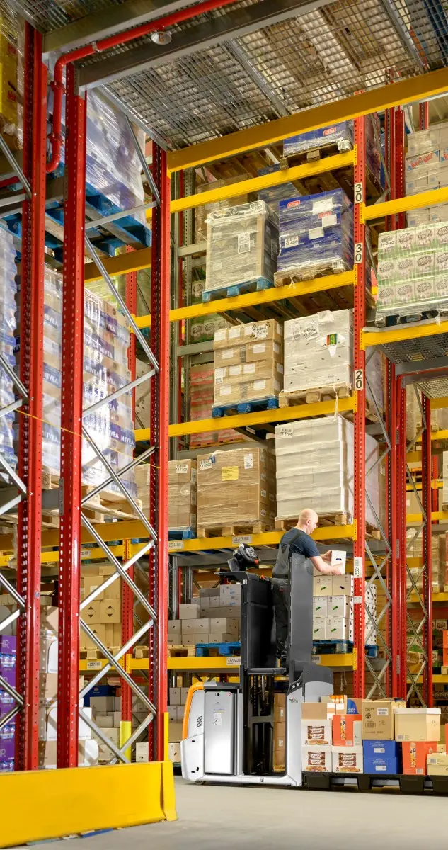 Yükseltilebilir operatör platformlu OPX 25 ile üst raf katından koli toplama (dikey görsel)