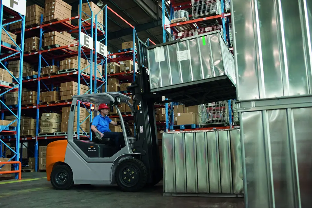 Raflı depoda metal kasa kaldıran STILL RC 42-35 forklift (RC 42 serisi uygulama fotoğrafı)