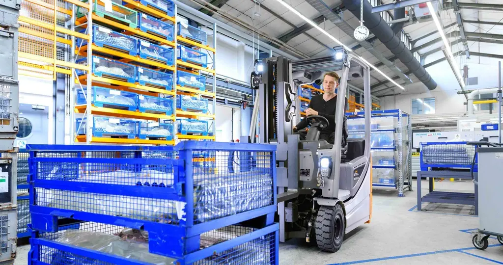 STILL RX 20 akülü forklift üretim alanında tel sepetli yükle çalışırken (görseldeki araç RX 20-16)