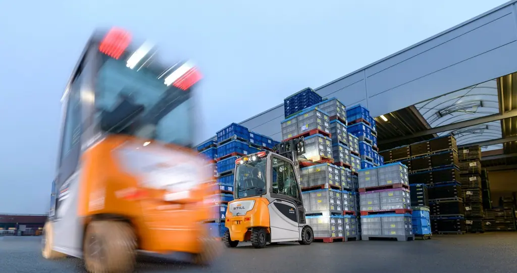 Dört tekerlekli, kapalı kabinli STILL RX 20-20 forklift açık alanda plastik kasa yüklü paletlerle çalışırken