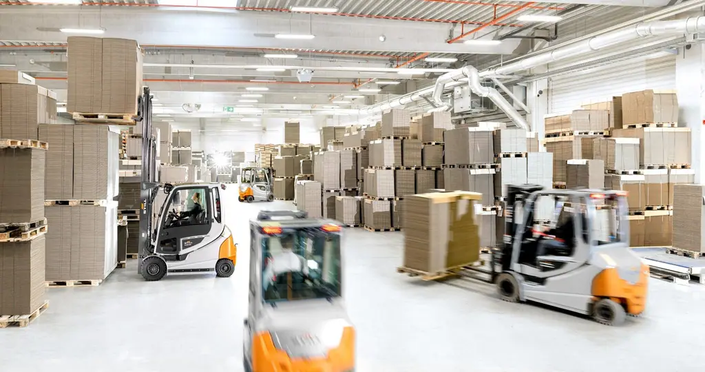 Karton stoklarının bulunduğu depoda birlikte çalışan STILL RX 60 serisi akülü forkliftler