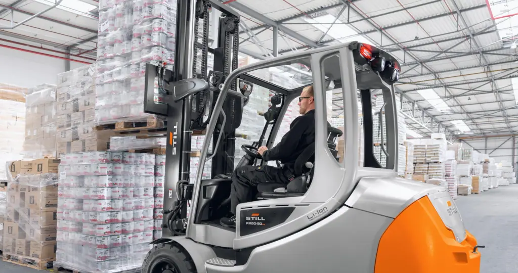 STILL RX 60-50 Plus lityum-iyon akülü forklift, depoda streçlenmiş paletleri istiflerken
