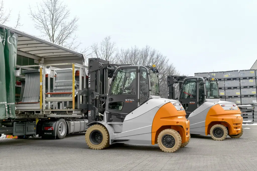 Açık sahada tenteli tıra yükleme yapan STILL RX 60-80; arkada bir STILL RX 60-80/900 duruyor