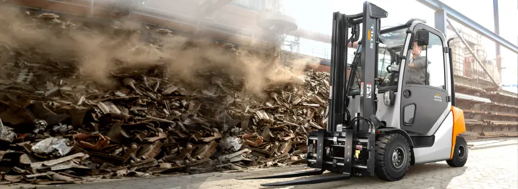 Hurda sahasında dış mekânda çalışan, hidrolik ataşmanlı ve kabinli STILL RX 70-25 forklift (STILL ARSER dizel forklift sahne görseli)